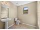 Powder room featuring a pedestal sink, toilet, and window at 11818 Gilmerton Dr, Riverview, FL 33579