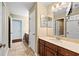 Hall bathroom with double sinks, cabinet, mirror, and tiled floors at 11818 Gilmerton Dr, Riverview, FL 33579