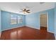 Bright bedroom featuring hardwood floors, ceiling fan, and natural light from large windows at 11818 Gilmerton Dr, Riverview, FL 33579