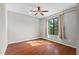 Cozy bedroom showcasing hardwood floors, a ceiling fan, and a bright window view at 11818 Gilmerton Dr, Riverview, FL 33579