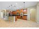 Open concept kitchen with stainless steel appliances, wood cabinets, granite counters, tile flooring, and an island at 11818 Gilmerton Dr, Riverview, FL 33579