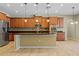 Bright kitchen features wood cabinetry, stainless steel appliances, a mosaic backsplash, and a kitchen island with pendant lighting at 11818 Gilmerton Dr, Riverview, FL 33579