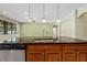 Granite countertop kitchen island features a stainless steel sink, faucet, dishwasher, and cabinets for storage at 11818 Gilmerton Dr, Riverview, FL 33579