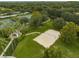 Aerial view of a sand volleyball court with lush green surroundings and a nearby covered picnic area at 11818 Gilmerton Dr, Riverview, FL 33579