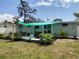 Backyard featuring a small patio, outdoor seating, refreshed landscaping, and a shade covering at 70 Virginia Ct, Englewood, FL 34223