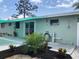 A charming backyard with a small patio area, updated landscaping, and a vibrant green exterior at 70 Virginia Ct, Englewood, FL 34223
