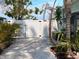 Gated backyard showcasing manicured landscaping, shell ground cover, and a white privacy fence at 70 Virginia Ct, Englewood, FL 34223