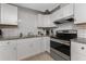 Modern kitchen featuring sleek stainless steel appliances and bright white subway tile backsplash at 70 Virginia Ct, Englewood, FL 34223
