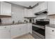Modern kitchen featuring sleek stainless steel appliances and bright white subway tile backsplash at 70 Virginia Ct, Englewood, FL 34223