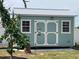 Exterior of a shed featuring double doors, windows, and clean, modern design with a bird feeder at 70 Virginia Ct, Englewood, FL 34223