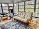 Cozy sun room featuring a comfortable sofa, cat tree, and natural lighting at 70 Virginia Ct, Englewood, FL 34223