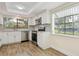 Updated kitchen with stainless steel appliances, white cabinetry, mosaic tile backsplash and wood-look flooring at 107 Seville N Ct, Plant City, FL 33566