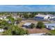 Aerial view of a quiet residential area with tidy homes, ample greenery, and a nearby community building with parking at 22131 Bahama Ave, Port Charlotte, FL 33952