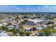 Aerial shot of a residential area featuring cozy homes, a community center, and a serene pond, all surrounded by lush trees at 22131 Bahama Ave, Port Charlotte, FL 33952
