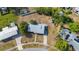 Aerial view of a cozy single-story home with a concrete driveway surrounded by lush greenery and mature trees at 22131 Bahama Ave, Port Charlotte, FL 33952