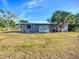 Back of home with grey paint and a large grass area at 22131 Bahama Ave, Port Charlotte, FL 33952