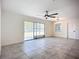 Bright living room featuring tile floors, a ceiling fan, and sliding glass doors at 22131 Bahama Ave, Port Charlotte, FL 33952