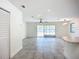 Bright living room boasts tile flooring, a ceiling fan, and sliding glass doors leading to a backyard at 22131 Bahama Ave, Port Charlotte, FL 33952