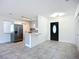 Open-concept living area featuring a stainless steel refrigerator, stylish kitchen, and decorative front door at 22131 Bahama Ave, Port Charlotte, FL 33952