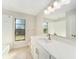 Bright bathroom featuring a large vanity and a shower tub combination with a window at 3419 Pleasant Lake Dr, Tampa, FL 33618