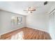 Comfortable bedroom with hard wood flooring, large window, and a ceiling fan at 3419 Pleasant Lake Dr, Tampa, FL 33618