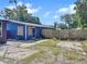 View of the home's backyard with grass, wood fencing, and blue exterior at 5213 Keene Dr, Plant City, FL 33566