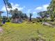 View of shed in backyard with grass and surrounding trees at 5213 Keene Dr, Plant City, FL 33566