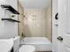 This well-lit bathroom features black shelving with tiled shower and white toilet at 5213 Keene Dr, Plant City, FL 33566