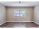 Bright bedroom featuring wood-look floors, neutral walls, and a window with blinds at 1409 N Garden Ave, Clearwater, FL 33755