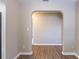 Bright hallway featuring an arched entryway, neutral paint, and durable wood-look flooring at 1409 N Garden Ave, Clearwater, FL 33755