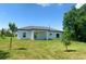New home featuring a large backyard, freshly laid sod, and trees at 4150 Windsong Ave, North Port, FL 34287