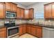 Modern kitchen with stainless steel appliances, dark granite countertops, and wood cabinets at 541 Vista Ridge Dr, Ruskin, FL 33570