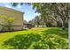Expansive backyard with lush green lawn, mature trees, and screened in pool area provides a private oasis at 2818 Mossy Timber Trl, Valrico, FL 33596