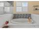 Luxurious bathroom with a soaking tub surrounded by marble tile and a tiled accent wall at 2818 Mossy Timber Trl, Valrico, FL 33596