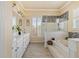 Bright bathroom featuring double sinks, a luxurious soaking tub and marble tiling at 2818 Mossy Timber Trl, Valrico, FL 33596