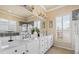 Bright bathroom featuring a double vanity with marble countertop and decorative backsplash, with a window providing natural light at 2818 Mossy Timber Trl, Valrico, FL 33596