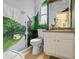 Bathroom with mural, white cabinetry, modern fixtures, and tile flooring provides a unique aesthetic at 2818 Mossy Timber Trl, Valrico, FL 33596
