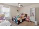 Cozy bedroom with a bed adorned with plush toys, complemented by a ceiling fan and natural light from a window at 2818 Mossy Timber Trl, Valrico, FL 33596