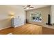 Well-lit bedroom with wood floors, a ceiling fan, and an expansive window view at 2818 Mossy Timber Trl, Valrico, FL 33596