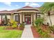 Charming single-story home with stucco exterior, a red tile roof, mature landscaping, and a covered front porch at 2818 Mossy Timber Trl, Valrico, FL 33596
