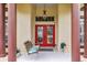 Inviting front porch featuring a hanging porch swing and double red doors at 2818 Mossy Timber Trl, Valrico, FL 33596