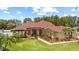 Lush front yard with manicured landscaping, palm trees and well-maintained lawn offers excellent curb appeal at 2818 Mossy Timber Trl, Valrico, FL 33596