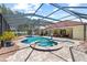 A relaxing screened-in pool and hot tub, surrounded by brick pavers at 2818 Mossy Timber Trl, Valrico, FL 33596