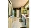 Well-lit bathroom with dual sinks, white cabinets, and neutral tile flooring at 30442 Lettingwell Cir, Wesley Chapel, FL 33543