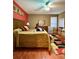 Bedroom with vibrant red wall, golden bedspread, and a patterned rug for added comfort at 30442 Lettingwell Cir, Wesley Chapel, FL 33543