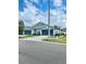 The exterior of a blue townhouse features a large two-car garage and well-kept landscaping at 30442 Lettingwell Cir, Wesley Chapel, FL 33543