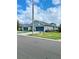 A blue townhouse's exterior shows well-manicured landscaping, a two-car garage, and a cozy garden at 30442 Lettingwell Cir, Wesley Chapel, FL 33543