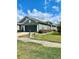 View of the home's front exterior highlighting the gray paint, dark garage, and landscaping at 30442 Lettingwell Cir, Wesley Chapel, FL 33543