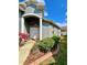 Charming home entrance with double doors, columns, landscaped yard, and flowerbed at 30442 Lettingwell Cir, Wesley Chapel, FL 33543