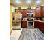 Stainless steel appliances and dark wood cabinets accent this modern and stylish kitchen at 30442 Lettingwell Cir, Wesley Chapel, FL 33543